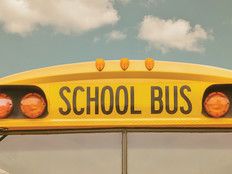 The front of a school bus against a cloudy sky