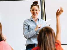 A teacher in the front of a classroom teaching students.