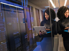 IT leader using a laptop computer next to servers