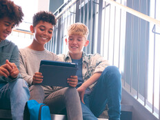 K12 students using tablet on school stairwell with great wi-fi
