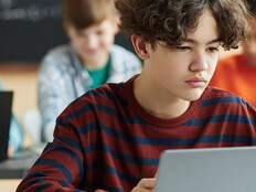 Boy using laptop computer in class