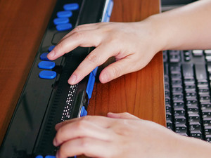 Blind student using braille technology