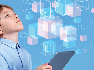 little boy holding tablet and looking at illustrated floating cubes