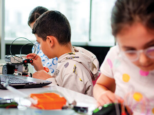 A group of children work together on some type of technology project