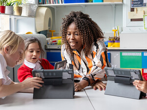 Teacher helping students with tech