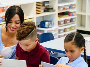 Teacher helping students with tech