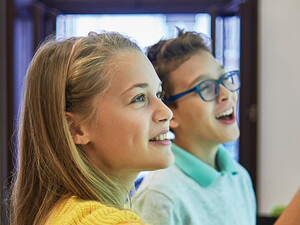 students smiling while writing on digital whiteboard