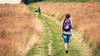 Rural k-12 students on grass road with backpacks